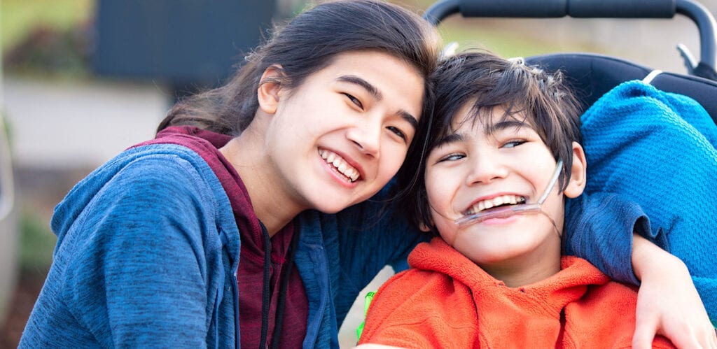 Two smiling young friends enjoying a moment together outside.