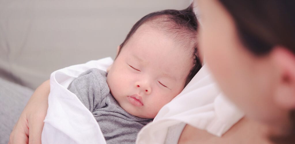 A peaceful baby sleeping on someone's chest.