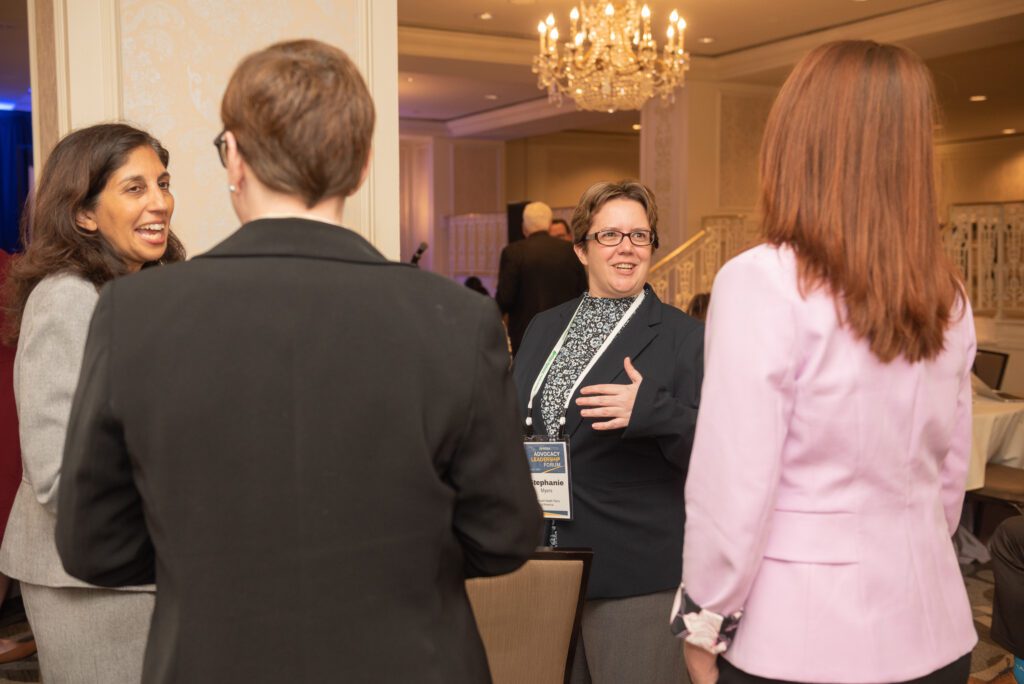 A woman giving a thumbs-up gesture at a social event.